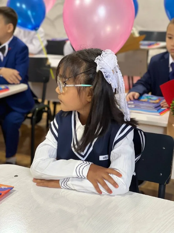 Maktab formasidagi qiz birinchi qoʻngʻiroq kuni partada oʻtiribdi