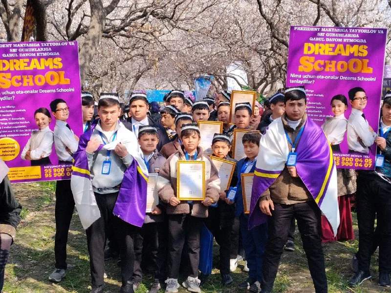 Doʻppi kiygan oʻquvchilar Navroʻz sayilida Dreams School bayroqlari ostida